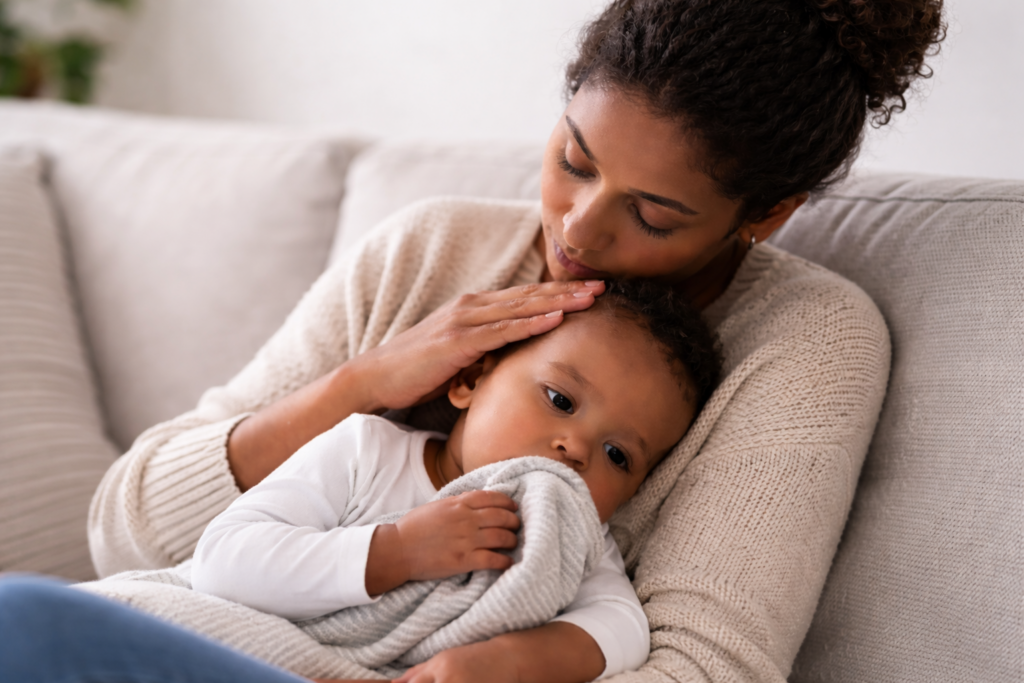 mother holding sick baby resting on her chest during illness while monitoring hydration