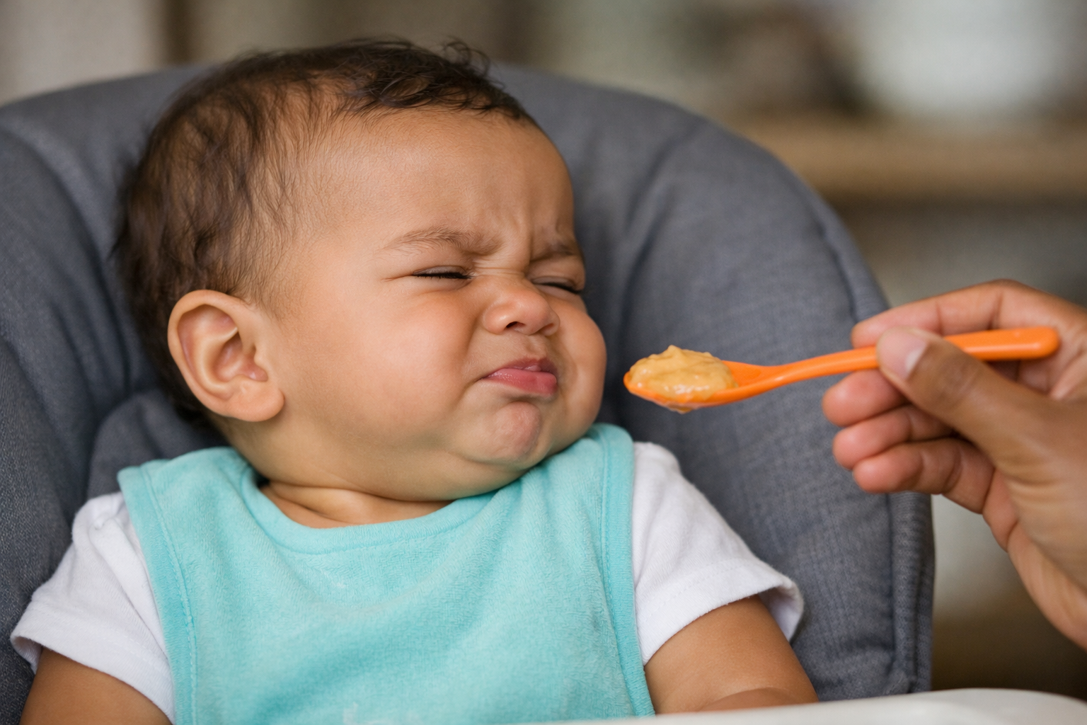 baby refusing food and turning head away from spoon during mealtime